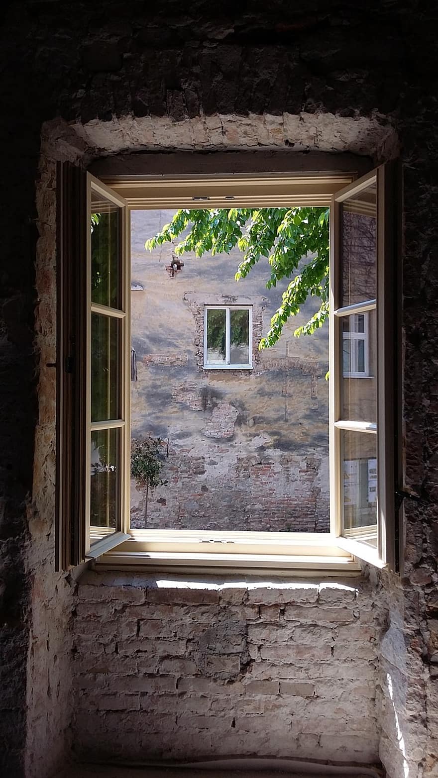 Una ventana de madera abierta de par en par