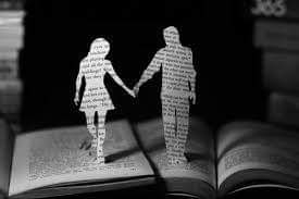 la silueta de un hombre y una mujer de la mano recortados de un libro. 